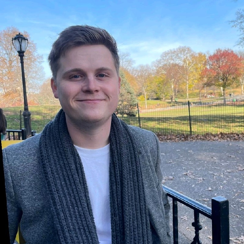 Jack, smiling at the camera sat in Central Park, NYC